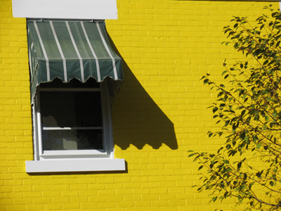 If you`re going to have a bright yellow house, you might as well have green awnings.