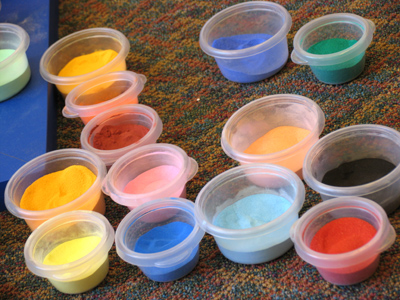It begins as grains of sand, with each color having a symbolic meaning.