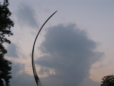 The pointy-eared orc raises its sword toward the hobbits.