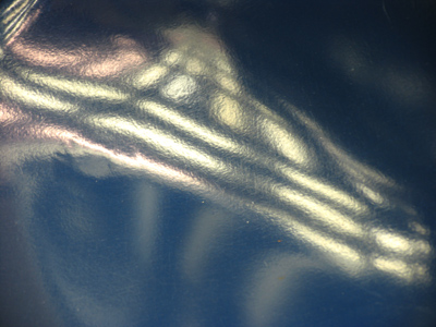 She sat on a blue plastic chair, bluer than plastic was the night.