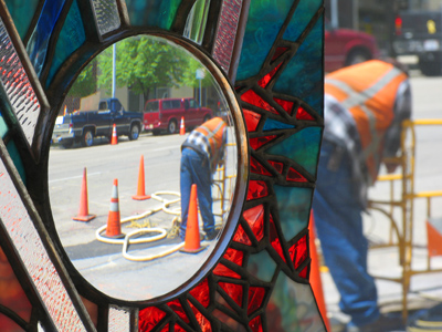 A city worker encased in a glass sculpture.  I use the term `worker` loosely.