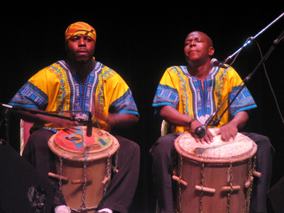 Two or three drummers pound out a driving rhythm beneath each song . . . 
