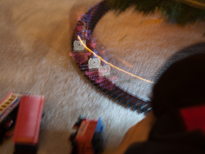 More picture-taking under the Christmas tree.  Someone else`s flash seems to create three toy trains.