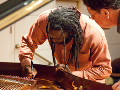 Awadagin Pratt, Very Famous Pianist, autographs the University`s new Bosendorfer grand piano.  I didn`t anticipate this, but jumped up on stage just in time.