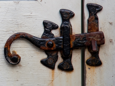 A six-legged, headless salamander?  Three guys carrying a big question mark?  A rusty latch on a white gate?