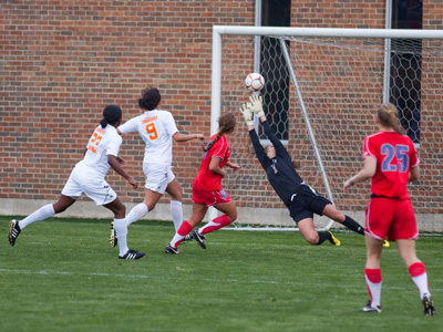 As the player in red scores, the one in black looks bad, but it`s really the ones in white who allowed it to happen.