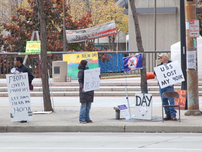 What do the Occupy protesters want, and how do they hope to achieve it by standing around on the sidewalk?