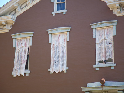 Most people put curtains INSIDE their windows.