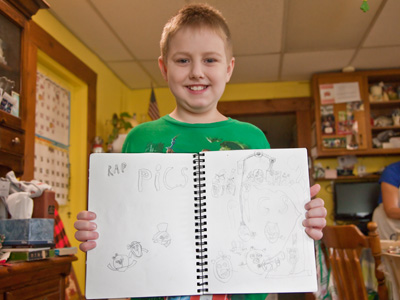 A future artist, proud of his creations.