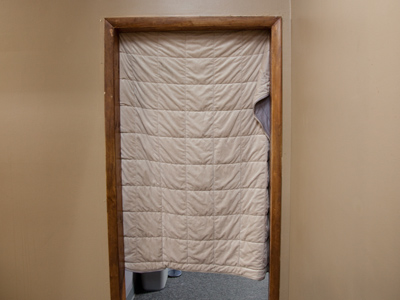 I work behind that door, and am always freezing in winter.  But someone discovered that a blanket will keep us warm.
