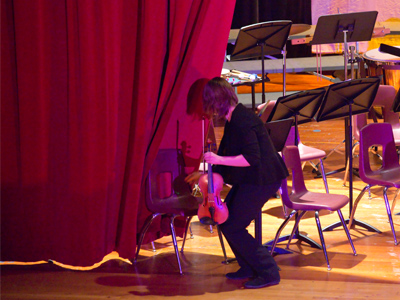 A violinist is consumed by a hungry curtain.
