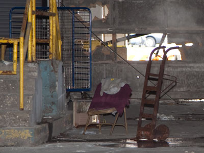 Yesterday`s fire in the abandoned garage was probably due to people living in it.  Note the comfy chair and old electric heater (and the door hacked open by firemen).