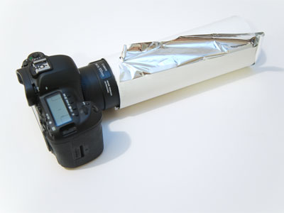 Roll it into a cylinder (with the reflective surface on the inside) and attach it to a camera lens.