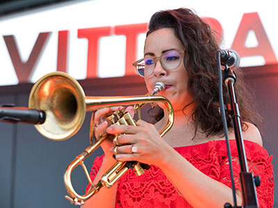 She plays trumpet with a Spanish accent.