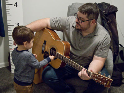 Helping daddy strum chords.