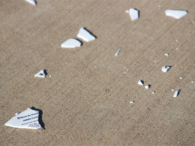 A dinner plate with writing on it was shattered across the sidewalk.  Hopefully it`s not a new TikTok trend.