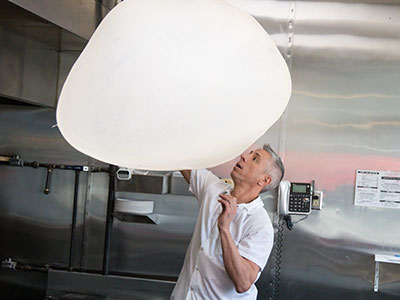 Other employees prepare ingredients, but only Frank and Tony spin the dough, flying it high over their heads.