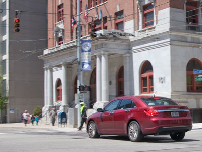 The car accelerated as the traffic light turned red. The pedestrian wisely chose not to walk into the street.  Just another bad driver in downtown Dayton.