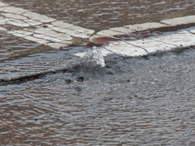 Remember the water main replacement project (see March 7, 10, and 22, 2023)?  Well, sumthin` didn`t take, cuz water`s bubbling up from under the street.