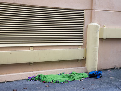 Warm air comes out of that vent, so somebody sleeps here.  There were many small bottles of sanitizer nearby.