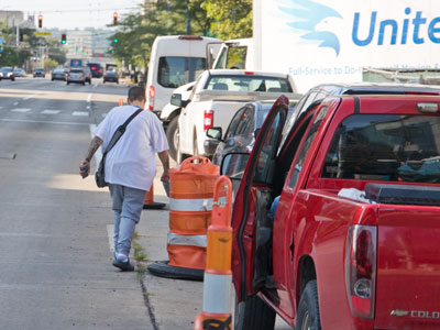 When construction workers park in the crosswalk, pedestrians have to take their chances in the street.