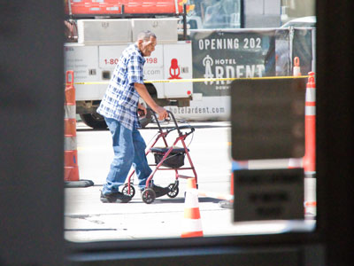 People walk in the street as the sidewalk is being rebuilt.