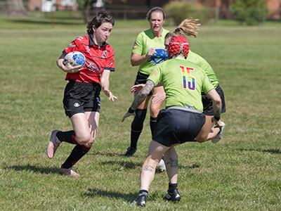 Wearing little more than a jersey and shorts, she runs full speed into a tackle.