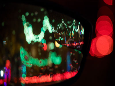 A neighbor`s decorated yard in my car mirror.